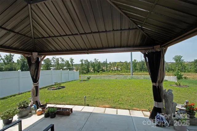 a view of a backyard with table and chairs under an umbrella