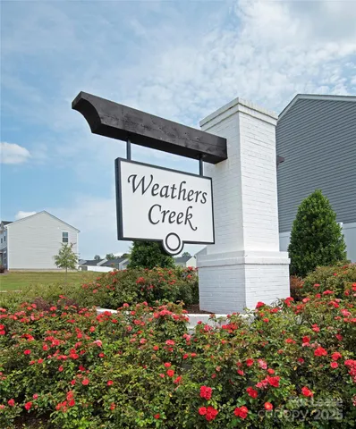 a view of sign board with buildings in background