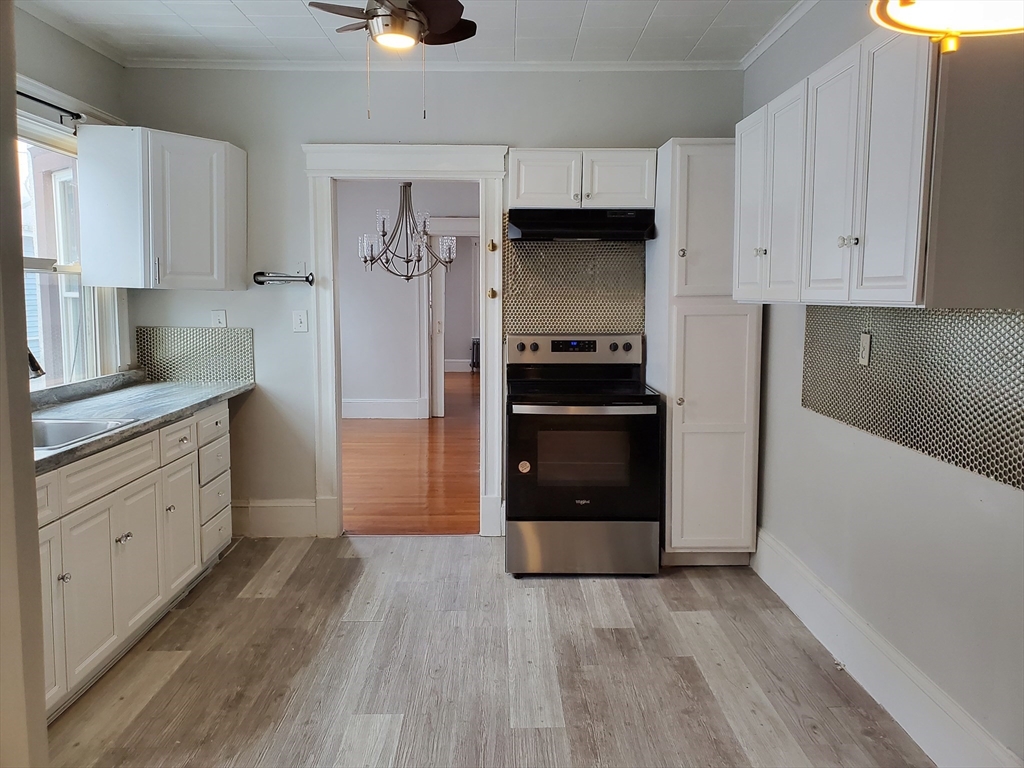 a kitchen with white cabinets and stainless steel appliances