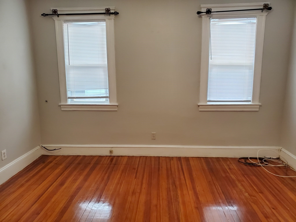 25 Kimberly Avenue, Unit 2 Springfield, MA 01108 - Photo 12 of 19 an empty room with wooden floor and windows