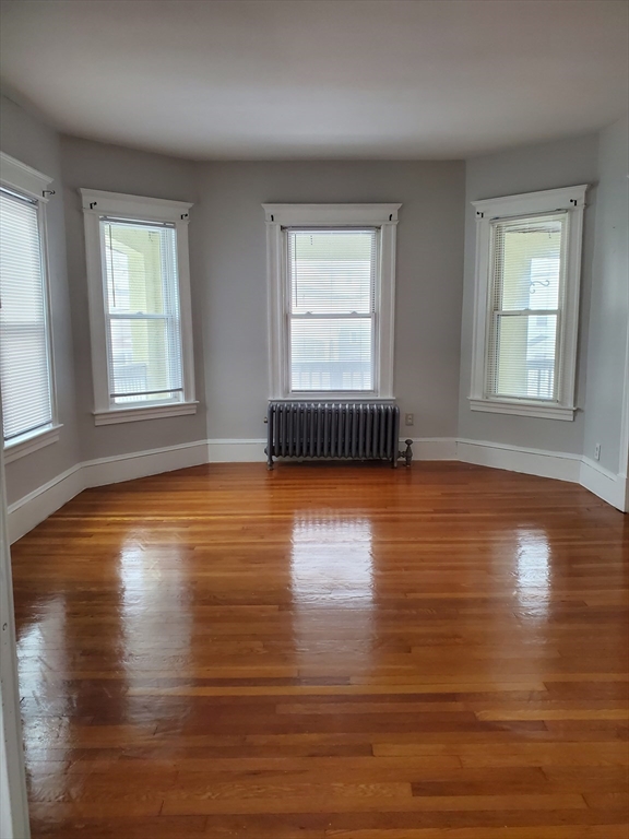 25 Kimberly Avenue, Unit 2 Springfield, MA 01108 - Photo 6 of 19 an empty room with wooden floor and windows