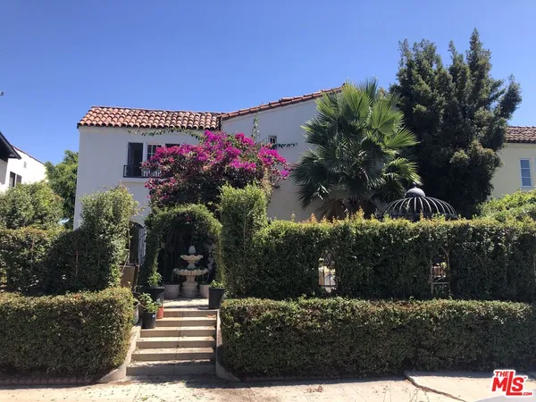 a front view of a house with a garden