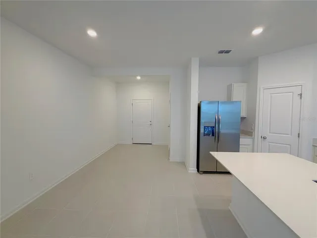 a view of a kitchen with refrigerator and a sink