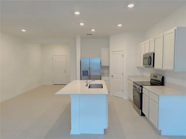a kitchen with kitchen island a sink stove and refrigerator