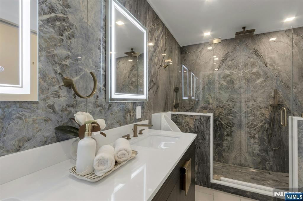 14 Rambling Brook Road Upper Saddle River, NJ 07458 - Photo 22 of 40 a bathroom with a granite countertop sink a mirror and shower