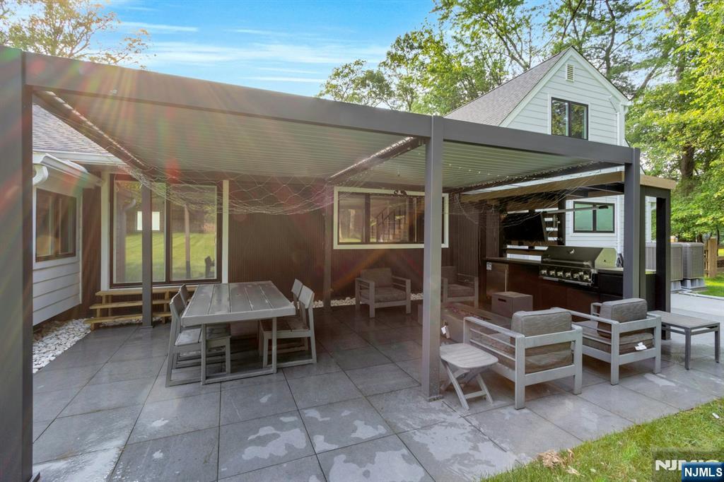 14 Rambling Brook Road Upper Saddle River, NJ 07458 - Photo 36 of 40 a view of a patio with a dining table and chairs with a patio