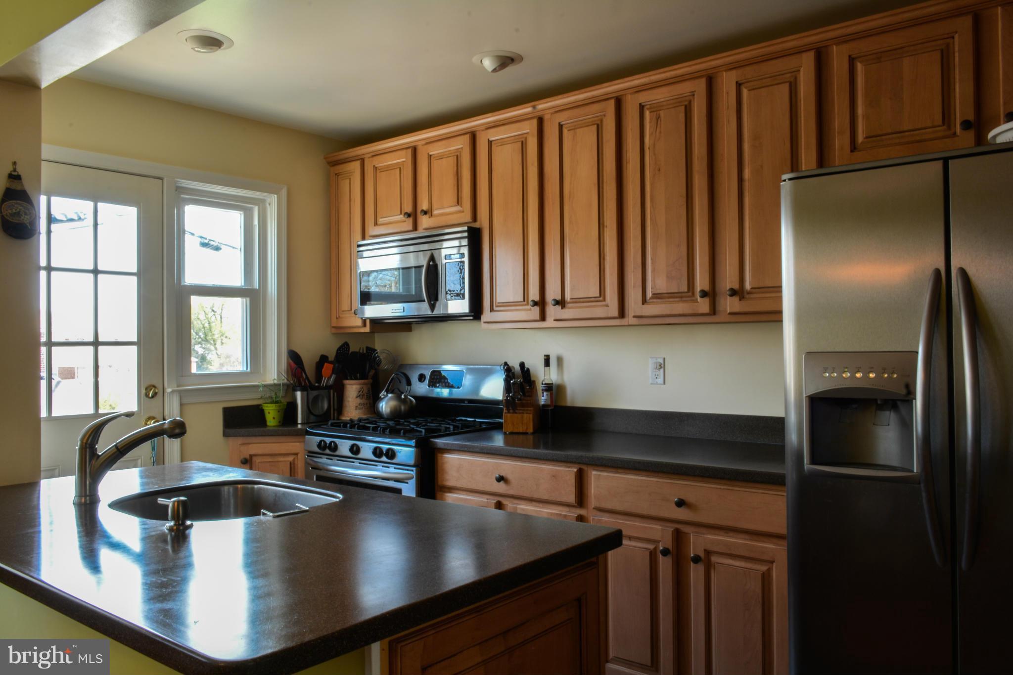 1604 Loch Ness Road Baltimore, MD 21286 - Photo 4 of 26 a kitchen with kitchen island a large counter top stainless steel appliances a sink and cabinets