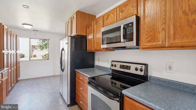 a kitchen with stainless steel appliances granite countertop a stove microwave and refrigerator