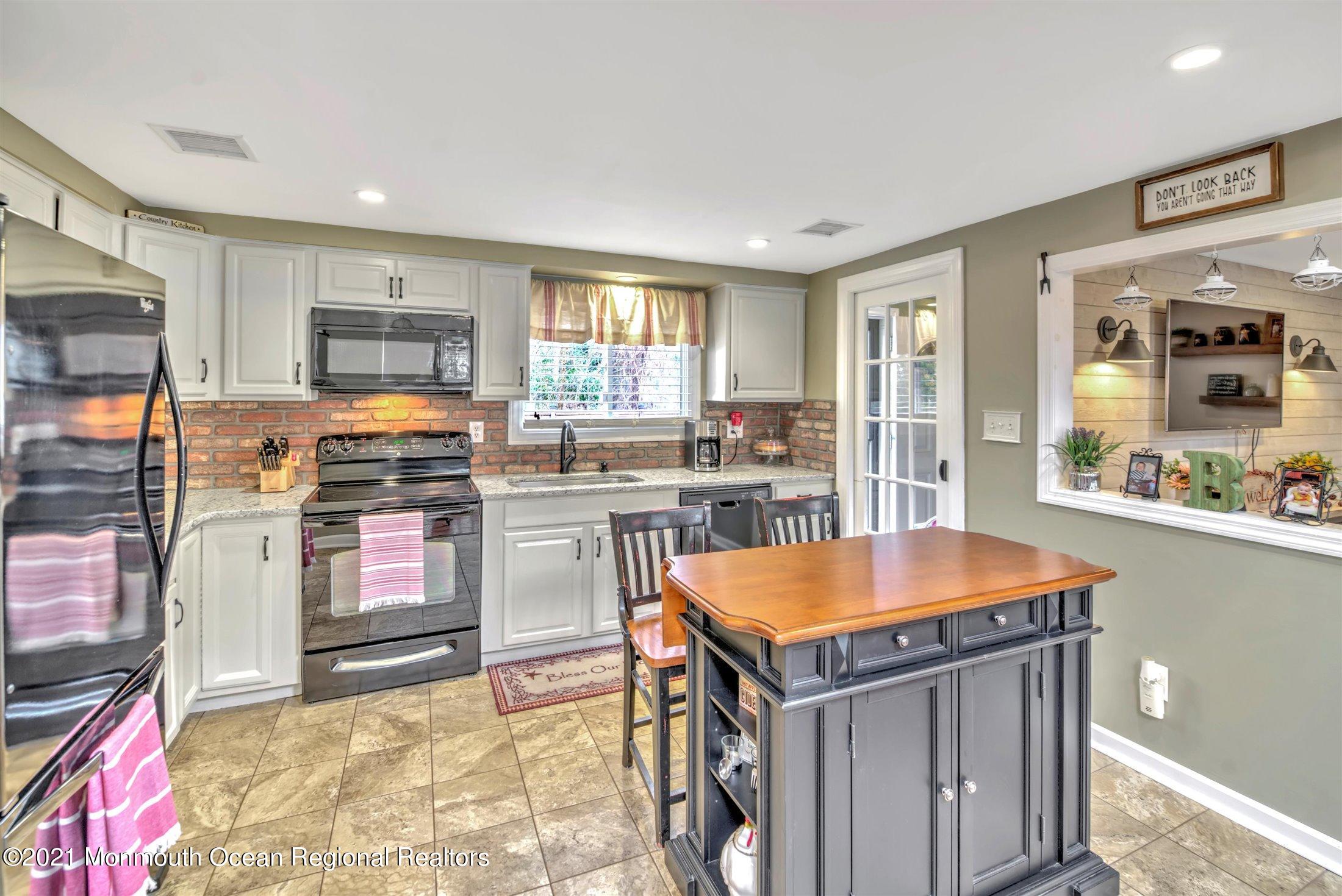 412 Conifer Drive Forked River, NJ 08731 - Photo 16 of 37 a kitchen with stainless steel appliances granite countertop a stove top oven a sink a dining table and chairs