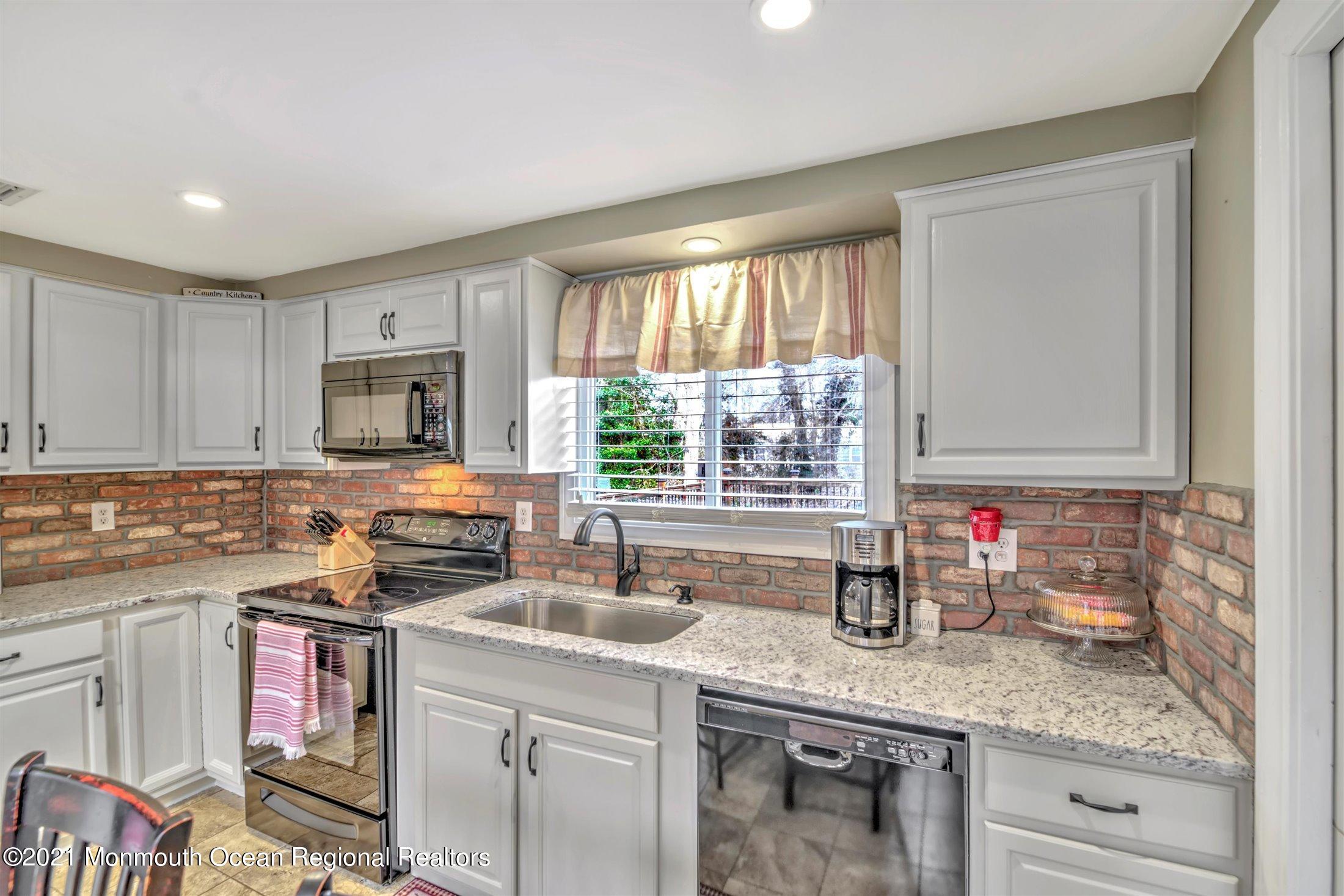 412 Conifer Drive Forked River, NJ 08731 - Photo 18 of 37 a kitchen with stainless steel appliances granite countertop a sink stove and cabinets