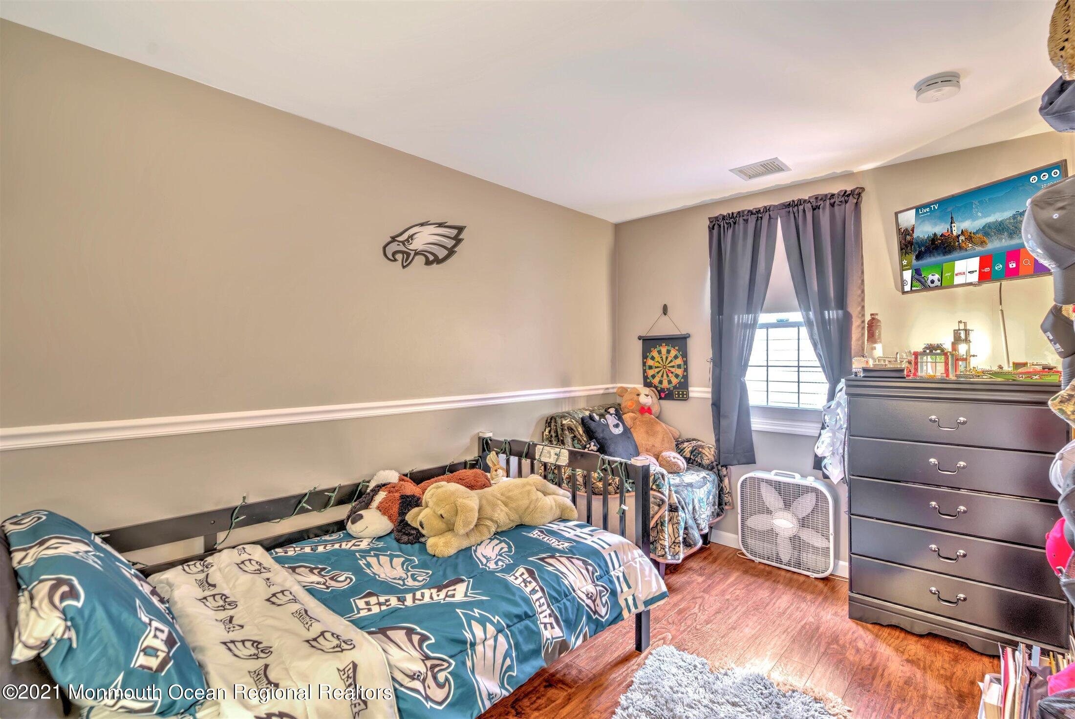 412 Conifer Drive Forked River, NJ 08731 - Photo 26 of 37 a bedroom with a bed and wooden floor