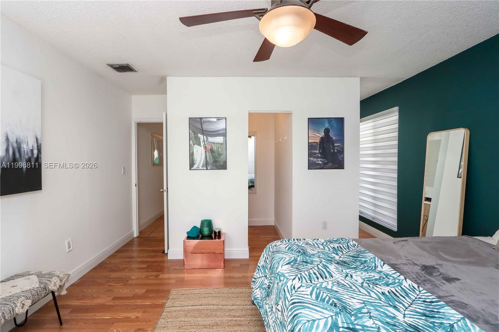 3155 Jackson Avenue Miami, FL 33133 - Photo 12 of 20 a bedroom with a bed and a chandelier