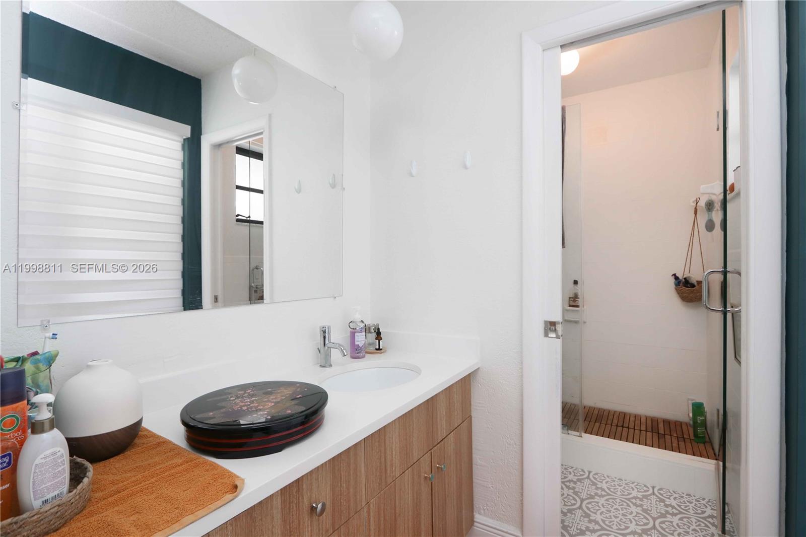 3155 Jackson Avenue Miami, FL 33133 - Photo 14 of 20 a bathroom with a granite countertop sink and a mirror