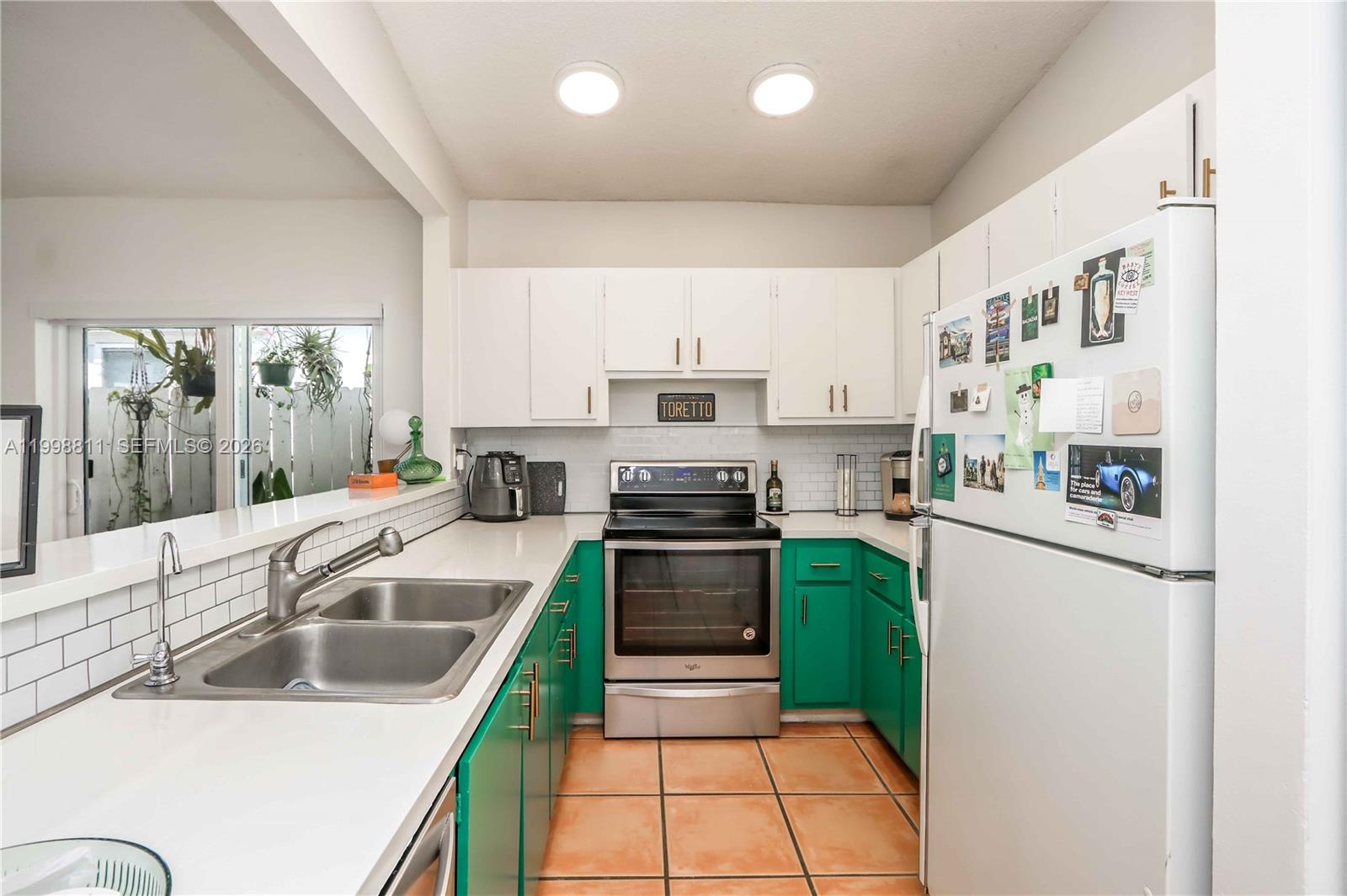 3155 Jackson Avenue Miami, FL 33133 - Photo 5 of 20 a kitchen with kitchen island a stove a sink and white cabinets