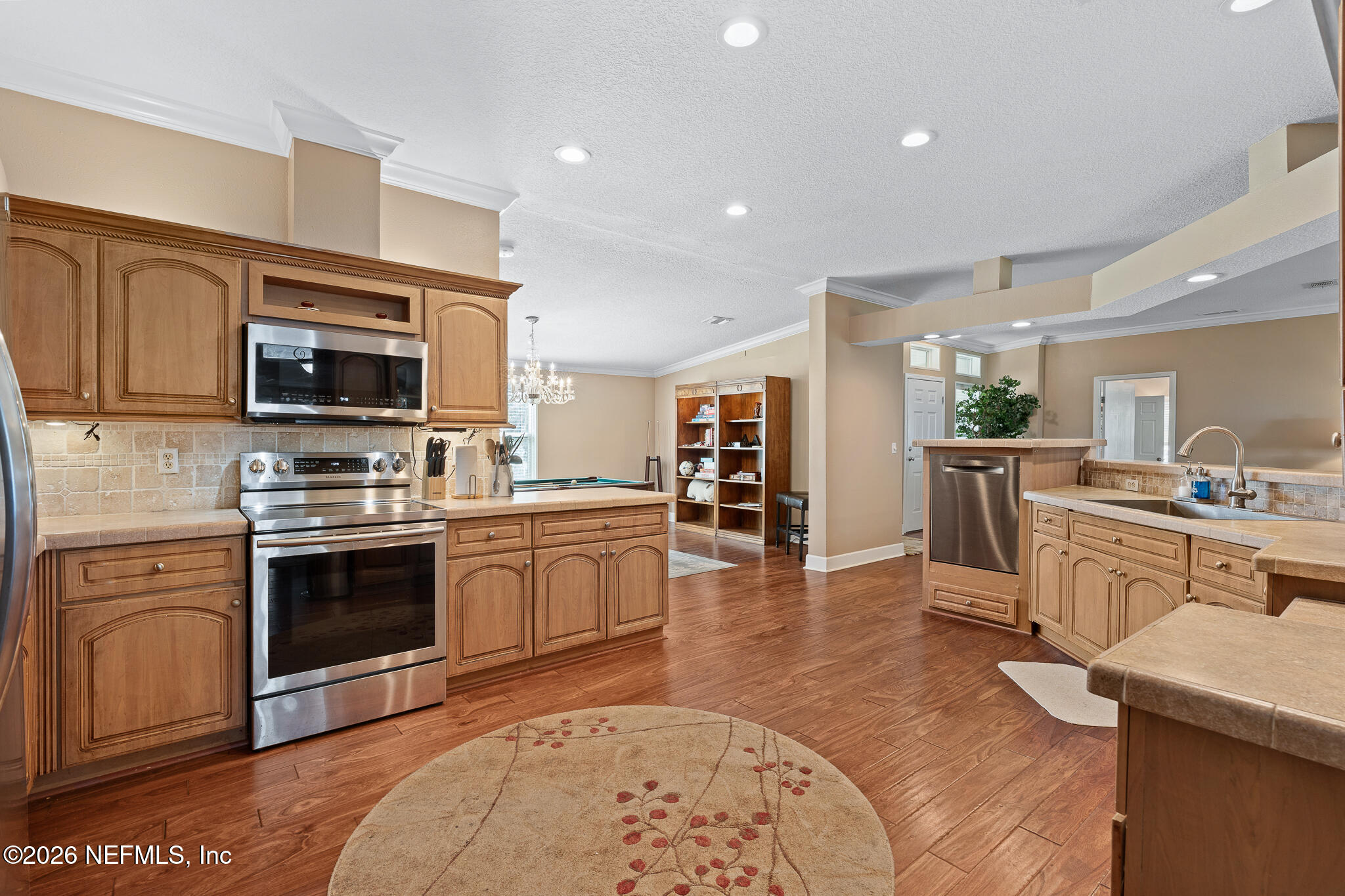 105 South Lake George Drive Georgetown, FL 32139 - Photo 11 of 30 a kitchen with stainless steel appliances kitchen island granite countertop a stove top oven a sink dishwasher a dining table and chairs with wooden floor