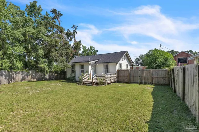 a view of a house with a yard and sitting area