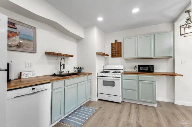 a kitchen with a sink cabinets and wooden floor