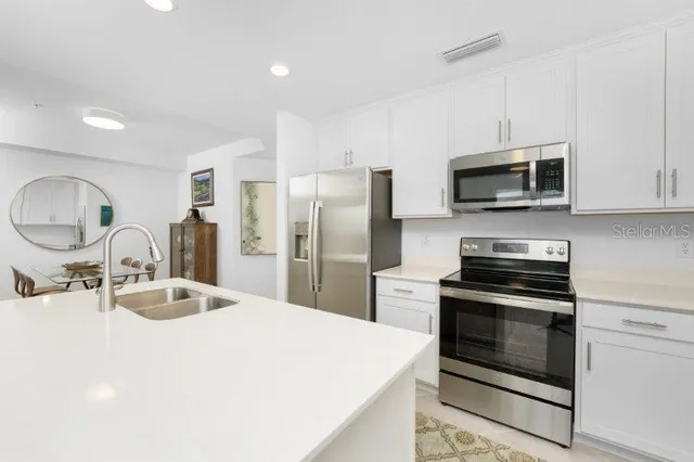 a kitchen with stainless steel appliances a stove microwave and sink