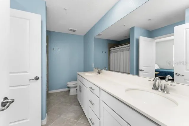 a bathroom with a sink a toilet and shower curtain