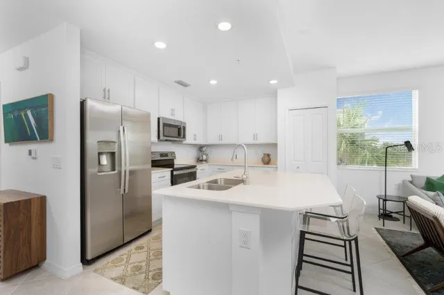 a kitchen with stainless steel appliances a refrigerator sink and microwave