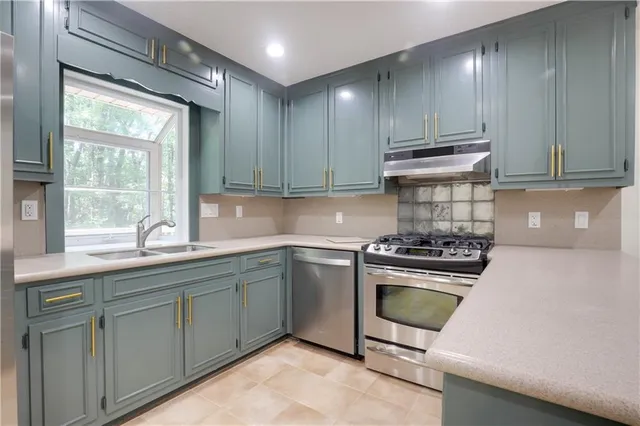 a kitchen with sink a stove and cabinets