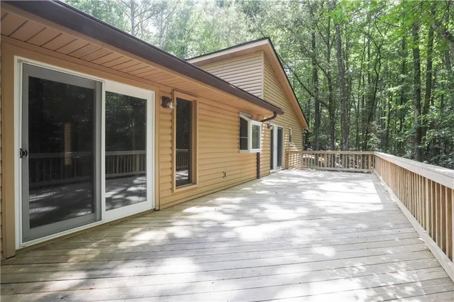 a view of backyard with large trees and wooden fence