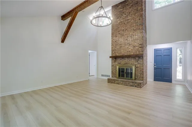 an empty room with wooden floor and fireplace