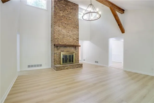 an empty room with wooden floor and stainless steel appliances