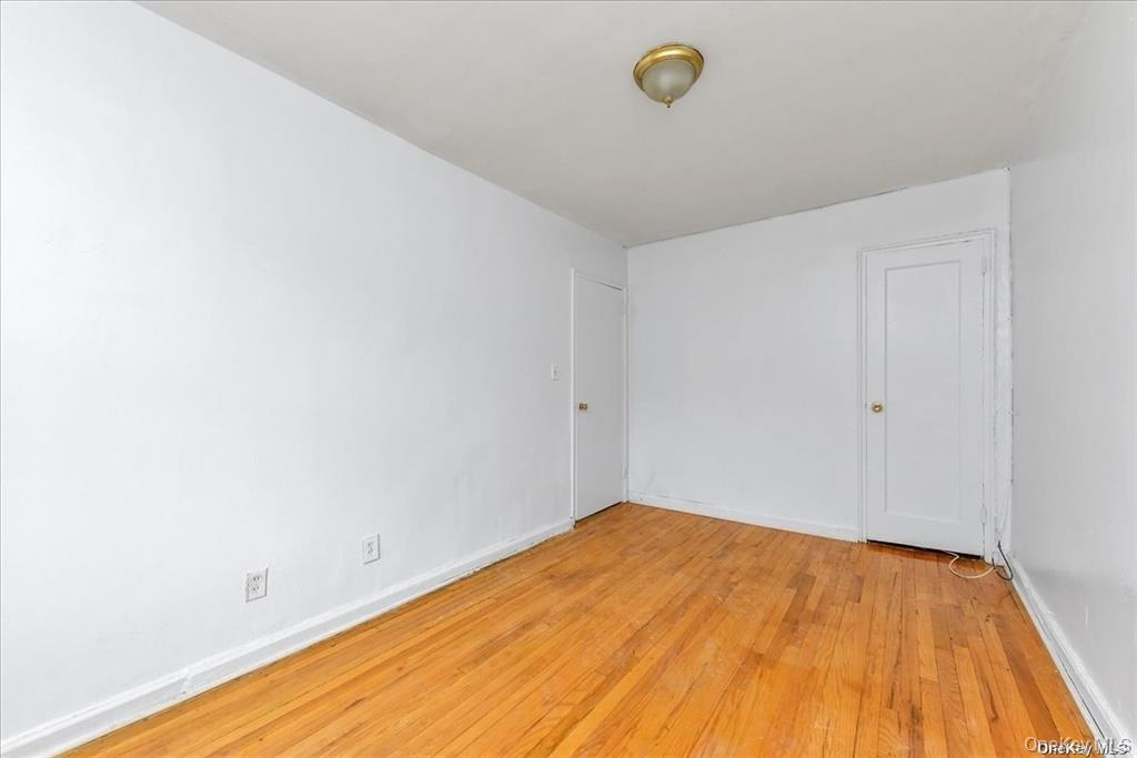 68-02 140th Street, Unit A Queens, NY 11367 - Photo 8 of 16 Spare room with light wood finished floors and baseboards