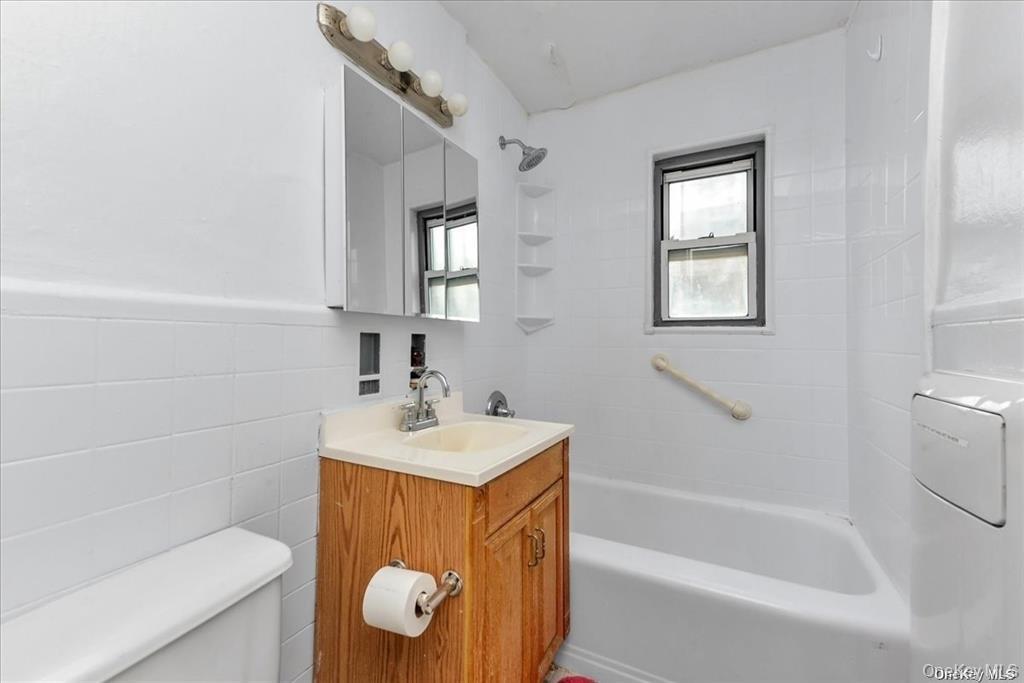 68-02 140th Street, Unit A Queens, NY 11367 - Photo 9 of 16 Full bath featuring tile walls, vanity, and bathing tub / shower combination