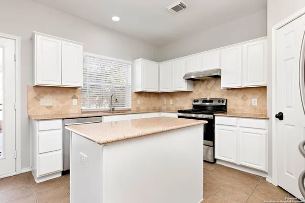 a kitchen with stainless steel appliances a sink stove and cabinets