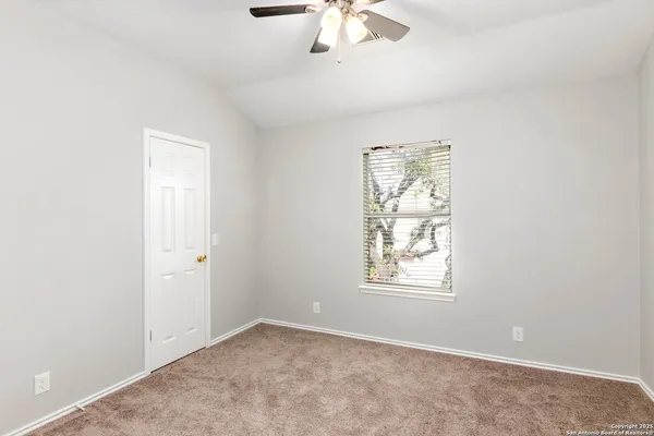 an empty room with windows and fan
