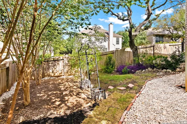 a view of backyard with a garden and trees