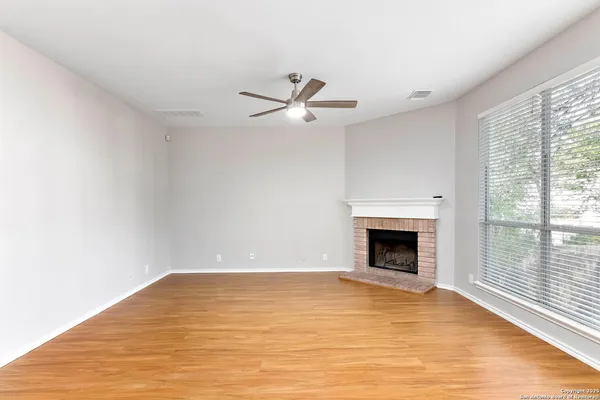 a view of empty room with fireplace and fan