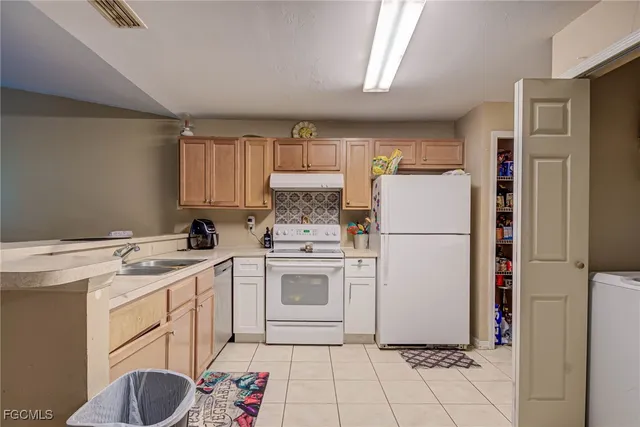 a kitchen with a refrigerator sink stove and cabinets