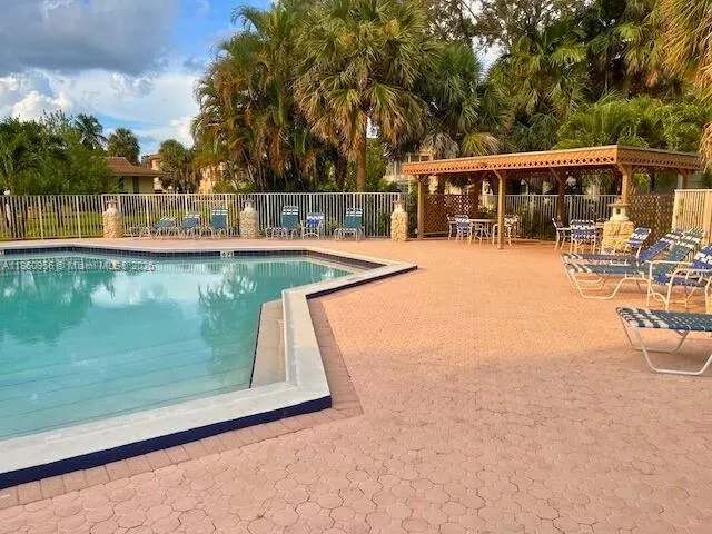 a view of a swimming pool with a patio and a yard