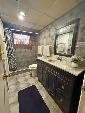 a bathroom with a sink a toilet a mirror and shower