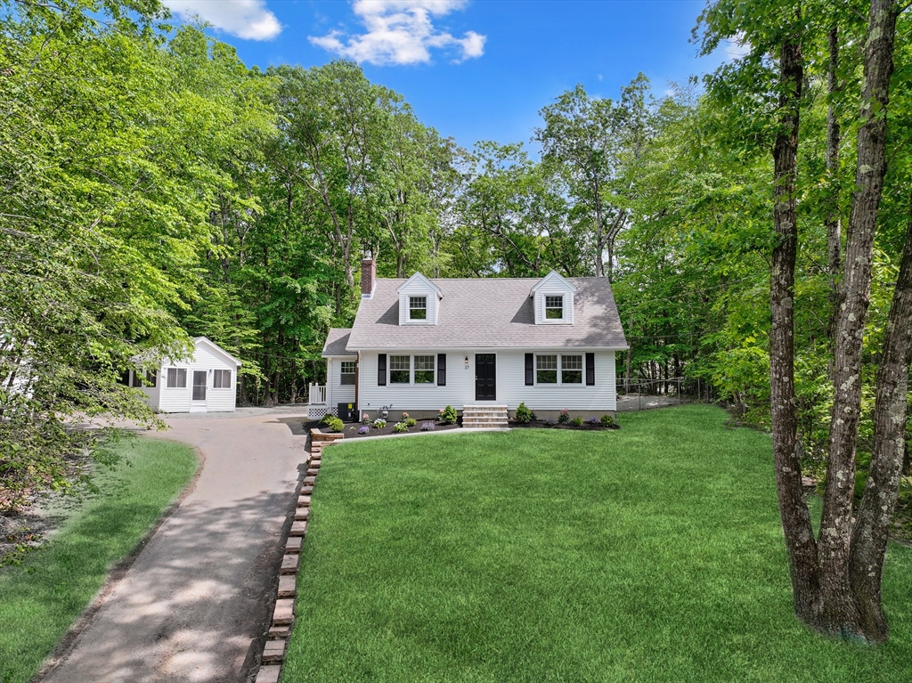 a view of a house with a big yard and large trees