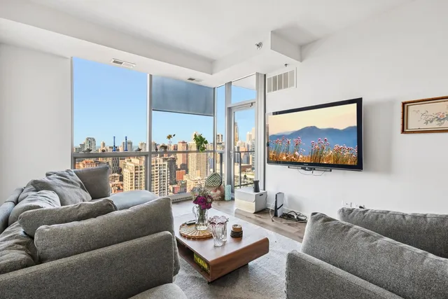 a living room with furniture and a view of kitchen