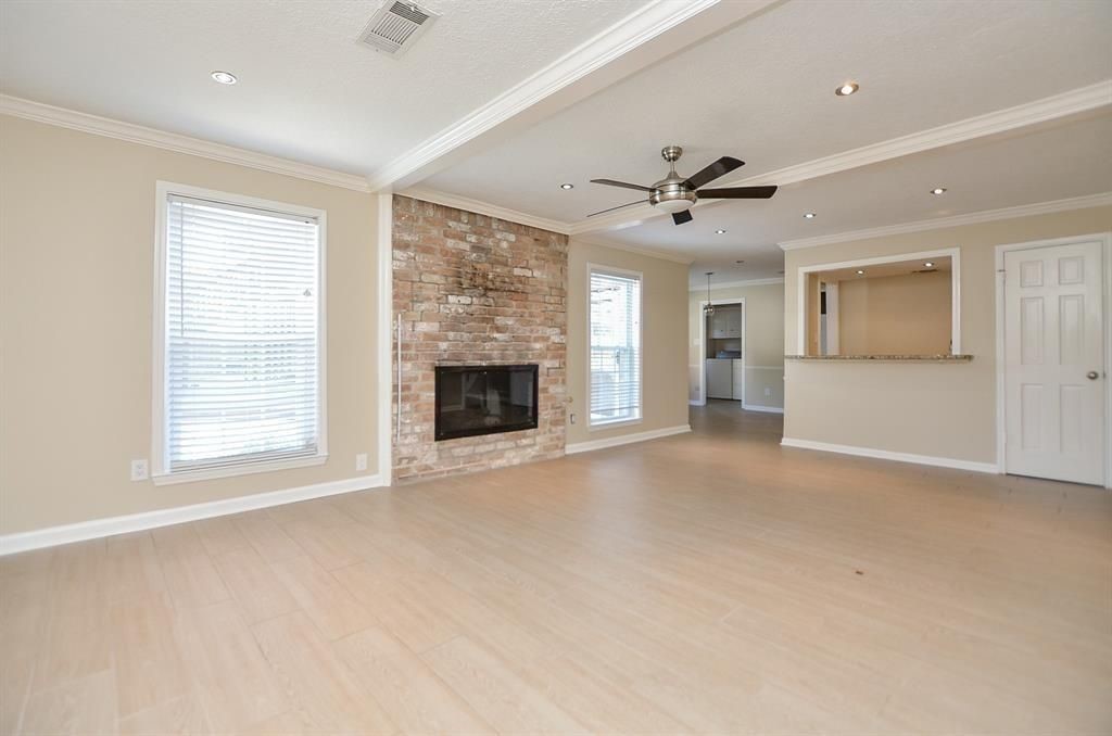 11502 Wickersham Lane Houston, TX 77077 - Photo 15 of 22 an empty room with chandelier fan and windows