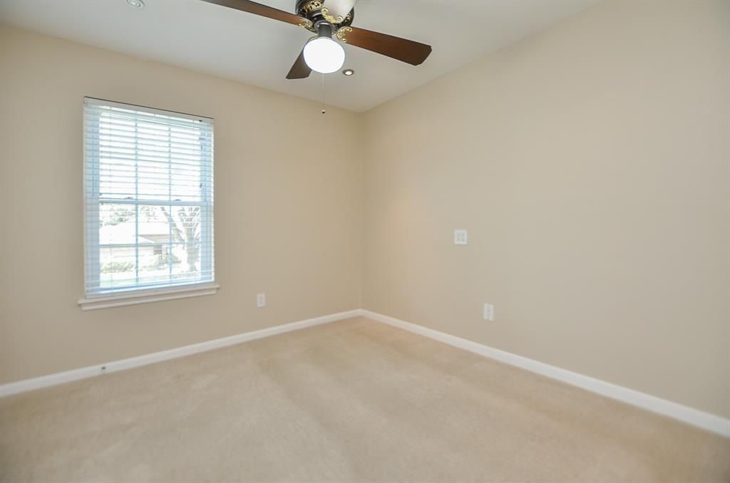 11502 Wickersham Lane Houston, TX 77077 - Photo 17 of 22 an empty room with a window and a fan