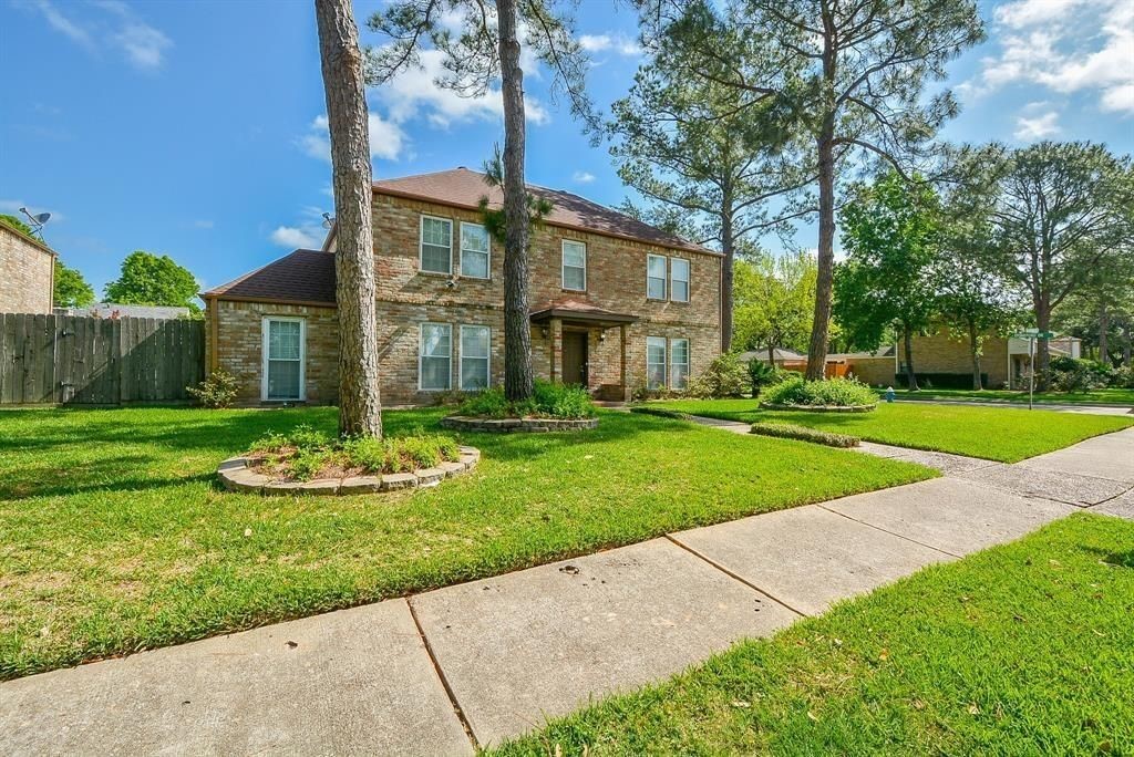11502 Wickersham Lane Houston, TX 77077 - Photo 2 of 22 a front view of a house with a yard and potted plants