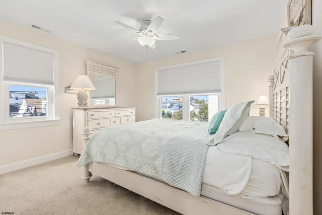 a bed sitting in a bedroom next to a window and a chandelier