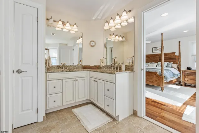 a spacious en suite bathroom with double sink and a mirror