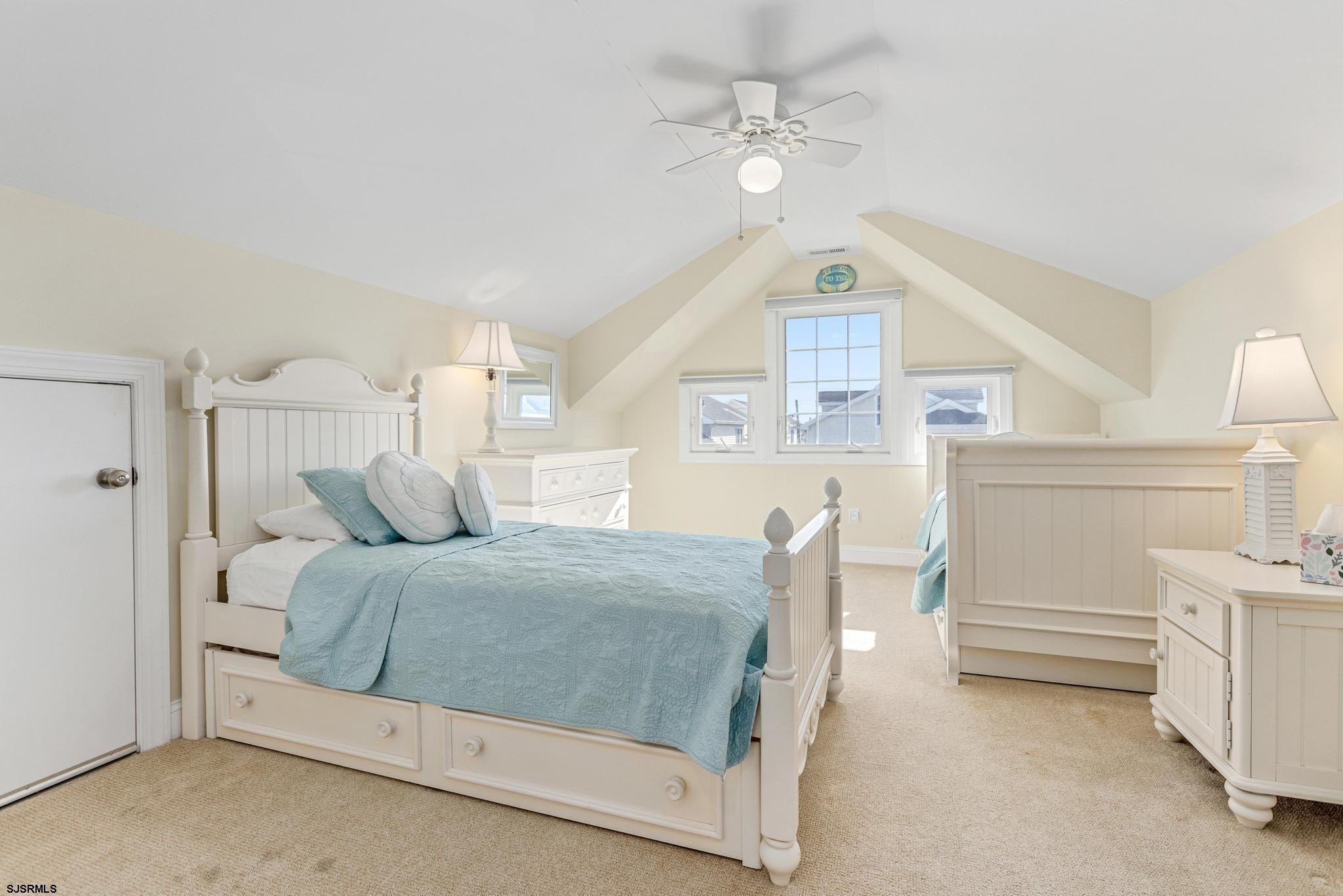 29 North Iroquois Avenue, Unit 6/16/26 FLEXIBLE WITH START DATE Margate City, NJ 08402 - Photo 31 of 40 a bedroom with a bed and a chandelier