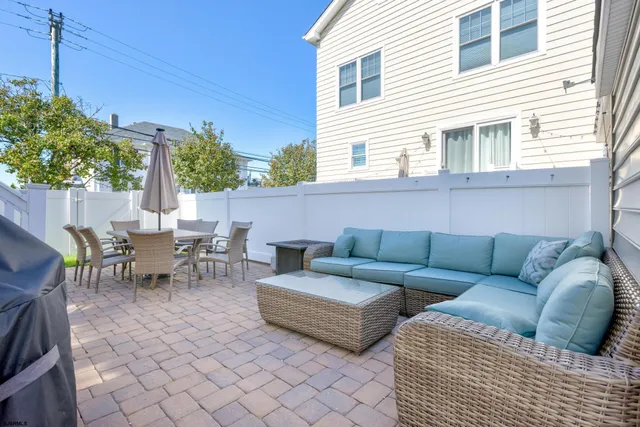 a view of a patio with couches and table and chairs with wooden fence
