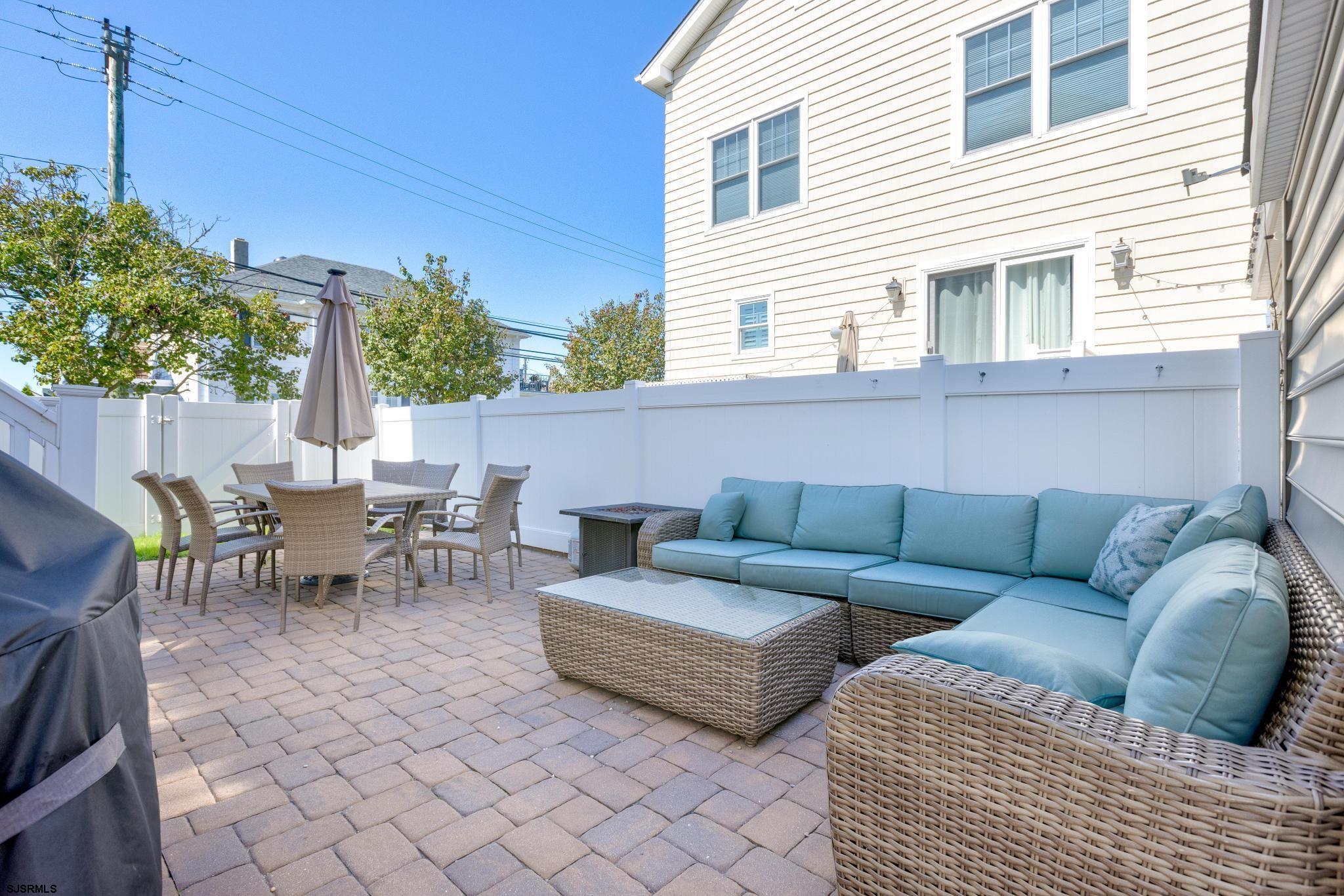 29 North Iroquois Avenue, Unit 6/16/26 FLEXIBLE WITH START DATE Margate City, NJ 08402 - Photo 36 of 40 a view of a patio with couches and table and chairs with wooden fence