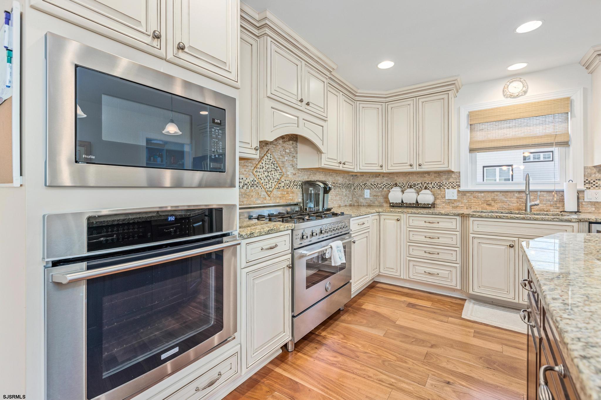 29 North Iroquois Avenue, Unit 6/16/26 FLEXIBLE WITH START DATE Margate City, NJ 08402 - Photo 6 of 40 a kitchen with granite countertop a stove top oven microwave and cabinets