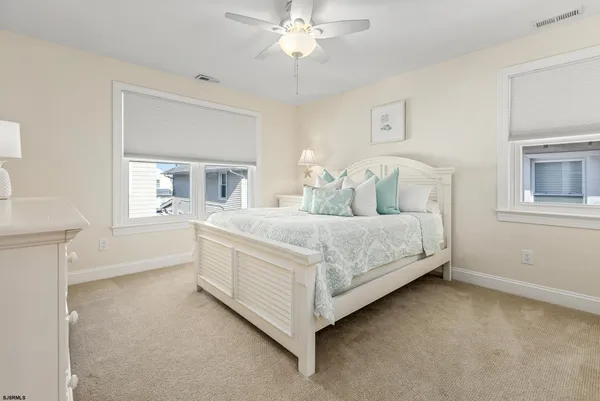 a bedroom with a large bed and a chandelier fan