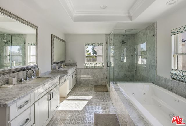 a bathroom with a granite countertop tub a sink and a large mirror